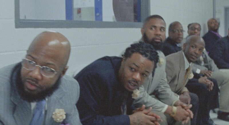 The fathers seated in a hallway waiting to see their daughters come through the door.