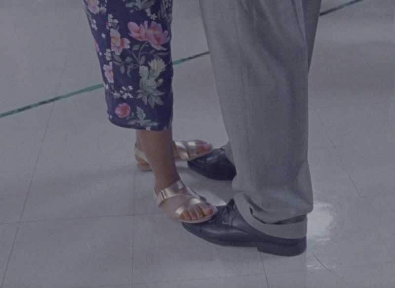 A father and daughter dance. She is standing on his feet.